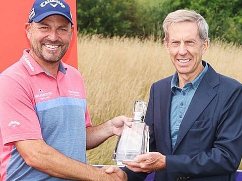 David Howell (left), winner of the 1999 Dubai Desert Classic, receiving his award for teeing it up in 700 tournaments on the DP World Tour from DP World Tour's Keith Waters.