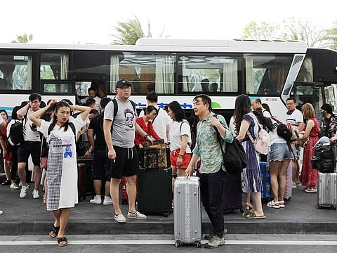 People get off a coach at an entrance of Atlantis Sanya resort in Sanya, Hainan province, China, November 25, 2020.