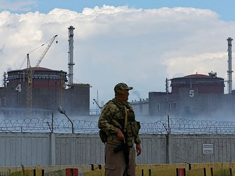 A serviceman with a Russian flag on his uniform stands guard near the Zaporizhzhia Nuclear Power Plant in the course of Ukraine-Russia conflict outside the Russian-controlled city of Enerhodar in the Zaporizhzhia region, Ukraine August 4, 2022.