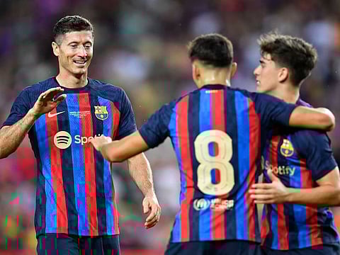 Barcelona's midfielder Pedri (centre) celebrates with forward Robert Lewandowski (left) and midfielder Gavi at the Camp Nou stadium in Barcelona.
