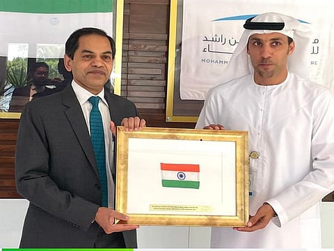 Indian Ambassador to the UAE Sunjay Sudhir receiving the special flag from Salem Humaid Al Marri, director general of Mohammed Bin Rashid Space Centre (MBRSC).