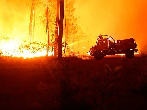 This photo provided by the fire brigade of the Gironde region SDIS 33, (Departmental fire and rescue service 33) shows firefighters tackling a blaze near Hostens, south of Bordeaux, southwestern France, Wednesday, Aug. 10, 2022.