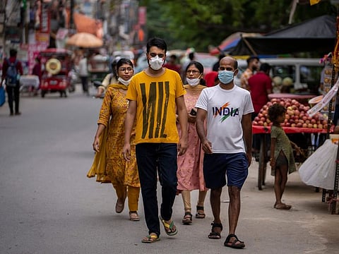 People wearing masks as a precaution against the coronavirus walk through a market in New Delhi, India, Thursday, Aug. 11, 2022.