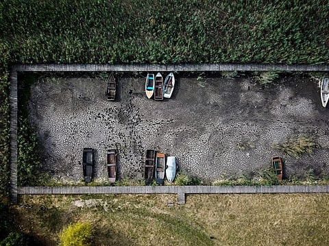 Boats lie on the dried lake bed in a port in Velence, Hungary, Thursday, Aug. 11, 2022.