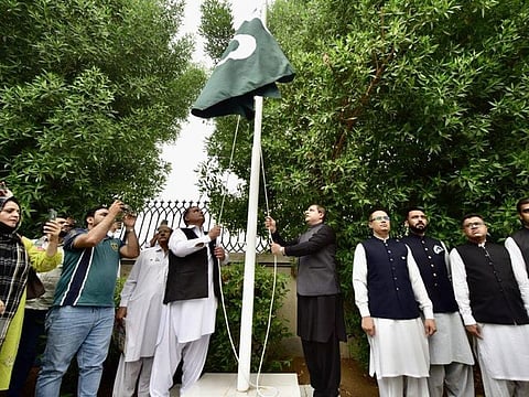 Consul General of Pakistan in Dubai Hassan Afzal Khan hoisting the Pakistani flag at the Pakistan Consulate in Dubai.