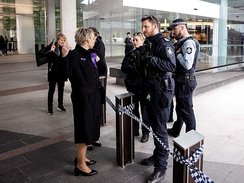 Police speak with witnesses after a gunman opened fire at the airport in Canberra on August 14, 2022.
