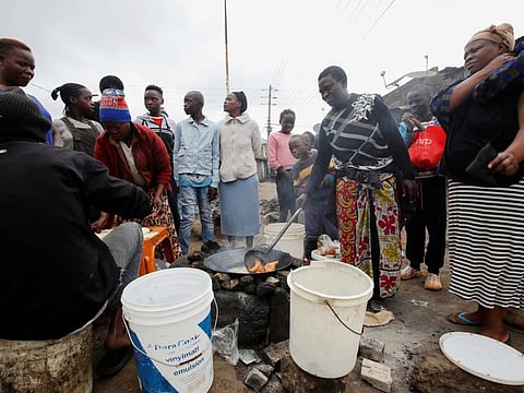 People gather to buy doughnuts for breakfast from a street vendor following announcement of the results of Kenya's presidential election, in Kawangware settlement of Nairobi, on August 16, 2022.