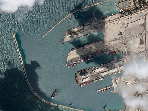This satellite image from Planet Labs PBC shows the Sierra Leone-flagged cargo ship Razoni, centre bottom with four white cranes on its red deck, at port in Tartus, Syria.