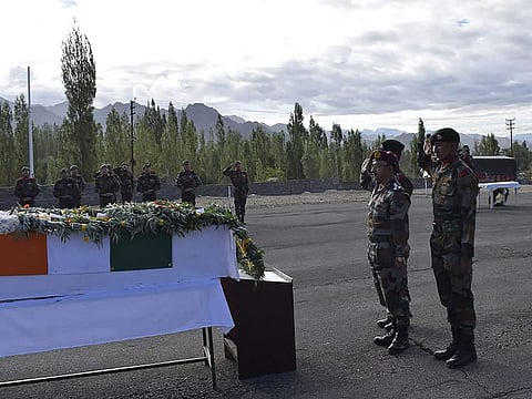 Indian soldiers salute in front of a coffin with the remains of Indian soldier Chander Shekhar, who went missing 38 years ago on a glacier on the disputed border with Pakistan, in Leh.