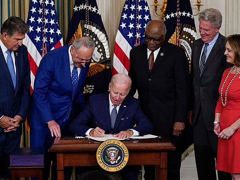 President Joe Biden signs the landmark bill in the State Dining Room of the White House