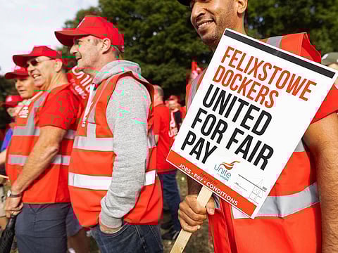 Striking dockers and members of the union hold placards and flags during the first day of a strike at the Port of Felixstowe in Felixstowe, UK, on August 21, 2022.
