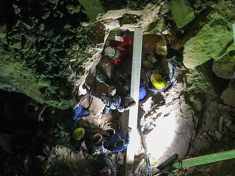 Members of Iraqi emergency services scan the rubble for victims following a landslide at the Qattarat Al Imam Ali shrine on the outskirts of the holy city of Karbala, late on August 20, 2022.