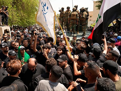 Supporters of Iraqi Shiite cleric Moqtada Sadr surround a vehicle with soldiers during a protest in front the Supreme Judicial Council, in Baghdad, on Aug. 23, 2022.