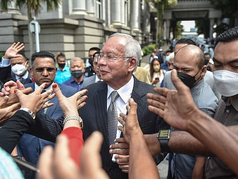 Malaysia's former prime minister Najib Razak greets supporters as he walks out during a break in the trial during an appeal against his corruption conviction over the 1MDB financial scandal, at the federal court in Putrajaya, on August 23, 2022.