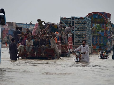 Displaced Pakistani families from flood-hit areas board vehicles while they move to safe place, in Nasirabad, a district of Pakistan's southwestern Balochistan province, on Aug. 22, 2022.