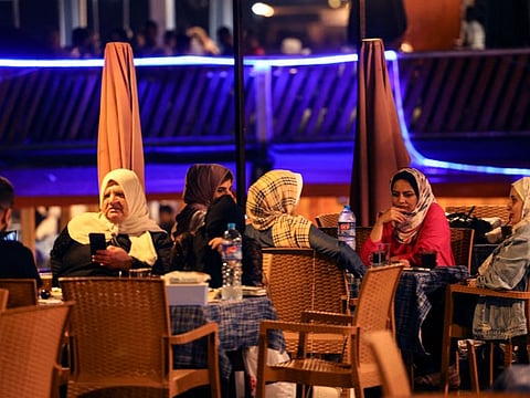 Palestinian women sit at a beach coffee shop in Gaza city, on July 2, 2022.