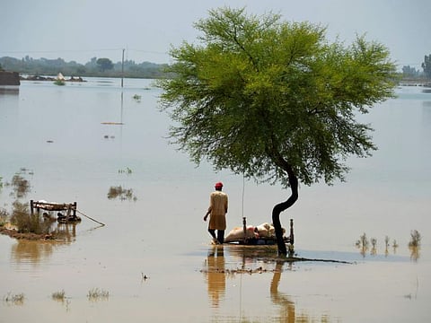 A villager uses cots to save usable items after salvaging from his flood-hit home, in Jaffarabad, a district of Pakistan's southwestern Baluchistan province, Saturday, Aug. 27, 2022.