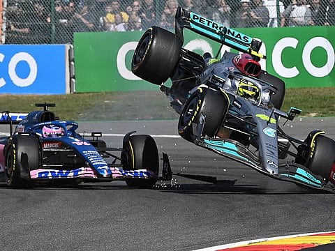 Mercedes' British driver Lewis Hamilton (R) collides with Alpine's Spanish driver Fernando Alonso (C) during the Belgian Formula One Grand Prix at Spa-Francophones racetrack at Spa, on August 28, 2022.
