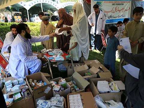 Women and children receive medical assistance at a relief camp for flood victims, following rains and floods during the monsoon season in Charsadda.