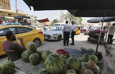 An Iraqi fruit vendor sits on August 31, 2022 in a street in the Iraqi capital Baghdad as calm returns after around 24 hours of deadly violence.