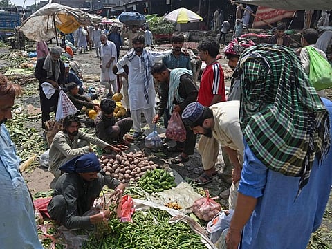 People buy vegetables at a local market in Lahore on August 30, 2022. Catastrophic monsoon floods in Pakistan have sent food prices skyrocketing, putting many staples out of the reach of the poor as the cash-strapped nation battles shortages.