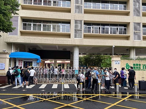 Volunteers arrive to a primary school repurposed for virus control efforts in Futian district, following the COVID-19 outbreak in Shenzhen, Guangdong province, on August 31, 2022.
