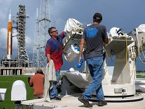 Nasa workers prepare a tracking camera near new moon rocket as she sits on Launch Pad 39-B.