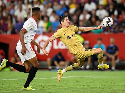 Barcelona's Robert Lewandowski (right) jumps to attempt a shot during the Spanish La Liga match against Sevilla in Seville, Spain.