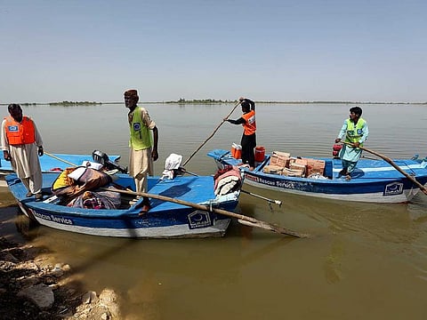 Victims of the unprecedented flooding from monsoon rains receive relief aid in Sukkur, Pakistan, in a file photo.