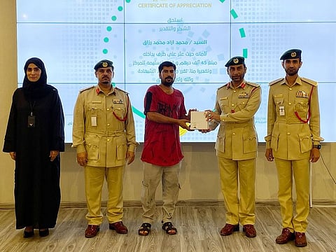 Mohammad Azad Mohammad Razaq receiving appreciation certificate from police officials at the Bur Dubai Police Station.