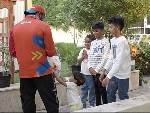 The siblings presenting gifts to a delivery rider