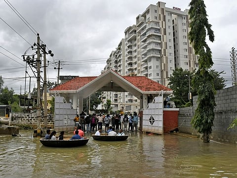 People use Coracle boats to move through a water-logged neighbourhood following torrential rains in Bengaluru, on September 7, 2022.
