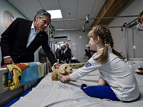 US Secretary of State Antony Blinken gives a gift to Marina, 6, from Kherson region, during a visit to a children hospital in Kyiv, Ukraine Thursday, Sept. 8, 2022.