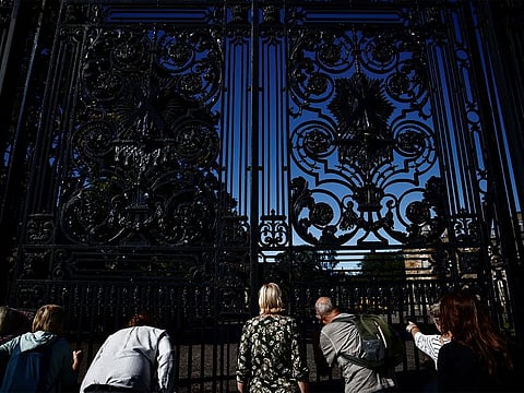 People look through the gates of the Palace of Holyroodhouse