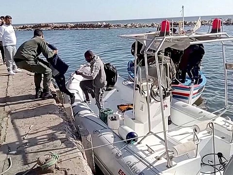 A Tunisian national coast guard helps a migran child to get off a rescue boat in Jbeniana, Safx, Tunisia April 23, 2022, in this screen grab taken from a handout video taken April 23, 2022.