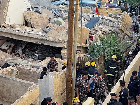 Rescuers work at the site of a residential building collapse in Amman on September 13, 2022.