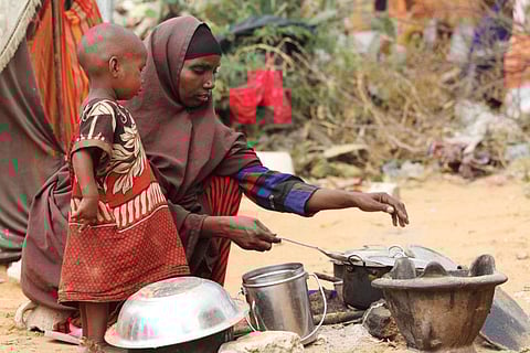 A woman cooks food for her children in a camp set up for internally displaced people in Dinsoor in a file photo.