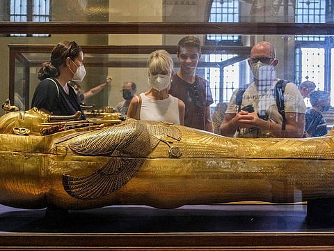 Tourists view the solid gold sarcophagus of the Ancient Egyptian New Kingdom Pharaoh Tutankhamun (1342-1325 BC), at the pharaoh's dedicated gallery in the Egyptian Museum in the centre of Egypt's capital Cairo on October 27, 2021.