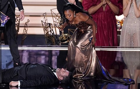 Quinta Brunson, right, winner of the Emmy for outstanding writing for a comedy series for "Abbott Elementary", checks on Jimmy Kimmel as he lays on stage at the 74th Primetime Emmy Awards on Monday.