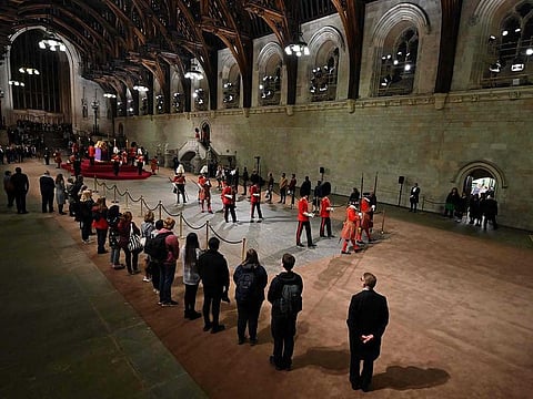 The guard is changed while members of the public pay their respects as they pass the coffin of Queen Elizabeth II as it Lies in State inside Westminster Hall, at the Palace of Westminster in London on September 14, 2022.