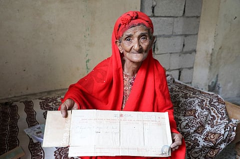 Kulthoom Muhammad Saeed, 80, shows her birth certificate as she talks to Reuters at her home about memories of the Queen Elizabeth's visit to Aden in 1954 during the period that Aden was a colony within the British Empire.