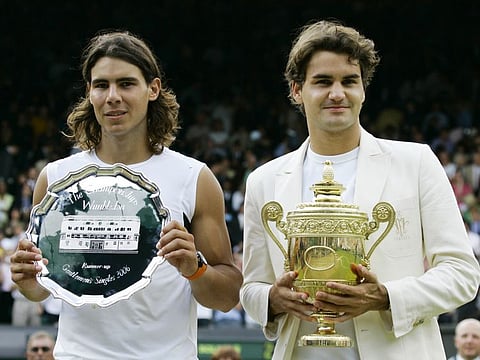 FILE - Defending champion Roger Federer, right, holds the winners trophy with runner up Rafael Nadal of Spain after the Men's Singles final on the Centre Court at Wimbledon, Sunday July 9, 2006. Federer won the match 6-0, 7-6, 6-7, 6-3. Federer announced Thursday, Sept.15, 2022 he is retiring from tennis. (AP Photo/Anja Niedringhaus, File)
