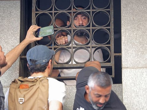 Abed Soubra, a depositor who stormed a bank demanding to withdraw his frozen savings, speaks from the window of the Blom Bank branch in the capital Beirut's Tariq Al Jdideh neighbourhood on September 16, 2022.