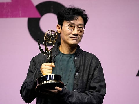 Squid Game's director Hwang Dong-hyuk poses with a trophy for the media during an Emmys celebration news conference for "Squid Game" in Seoul, South Korea, Friday, September 16.