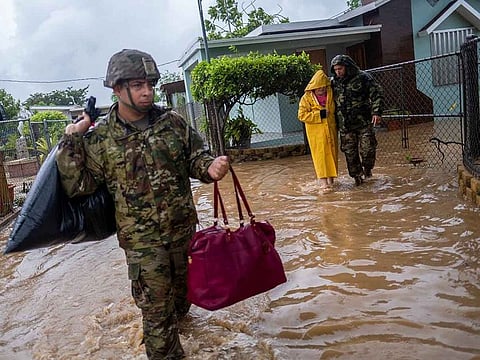 Members of the Puerto Rico National Guard rescue a woman stranded in her house in the aftermath of Hurricane Fiona in Salinas, Puerto Rico September 19, 2022.