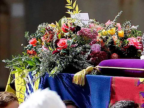 A white note by King Charles III is seen nestled amid a richly symbolic floral spray.