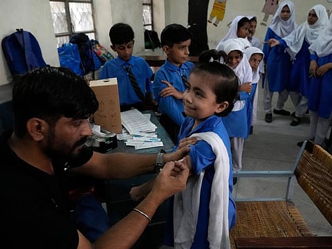 A schoolgirl receives the Pfizer BioNTech COVID-19 vaccine at a school in Lahore on September 19, 2022.