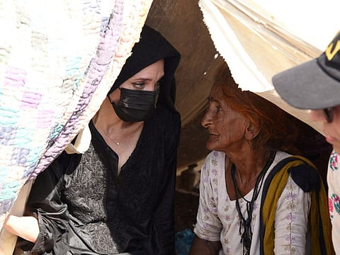 Angelina Jolie listens to a displaced woman following rains and floods during the monsoon season, in village Ibrahim Chandio, Dadu, Pakistan September 20, 2022.