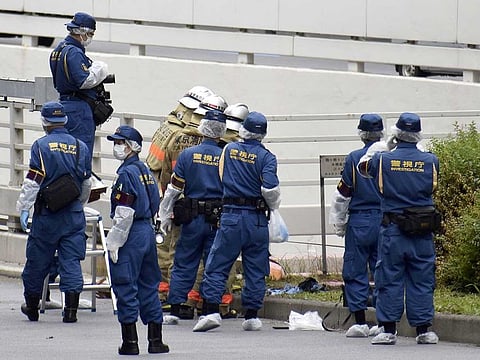 Police officers and firefighters investigate at the site where a man who was protesting a state funeral for former Japanese Prime Minister Shinzo Abe set himself on fire, near Prime Minster Fumio Kishida's official residence in Tokyo, Japan September 21, 2022, in this photo taken by Kyodo.