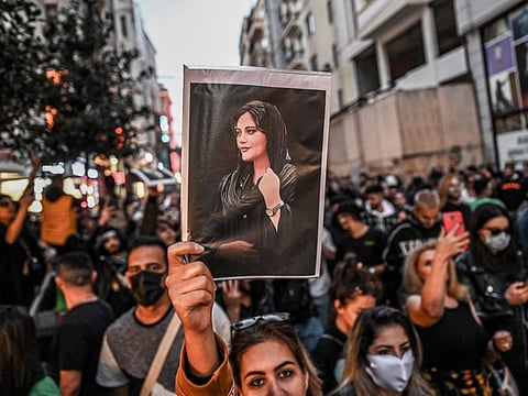 A protester holds a portrait of Mahsa Amini during a demonstration in support of Amini, a young Iranian woman who died after being arrested in Tehran by the Islamic Republic's morality police, on Istiklal avenue in Istanbul on September 20, 2022.